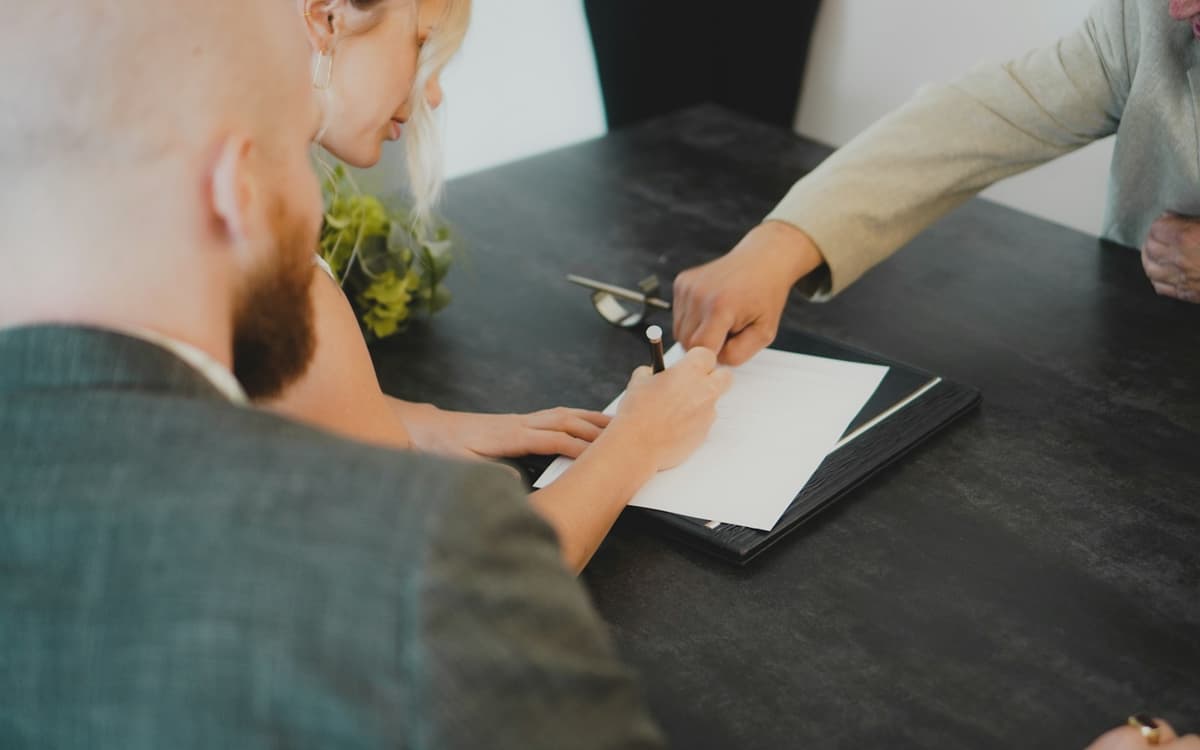 An employment contract being handed across a desk