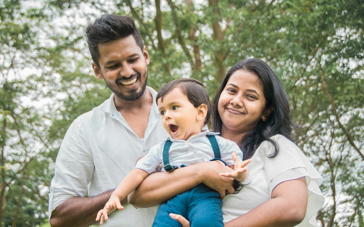 A young family — two parents holding their child