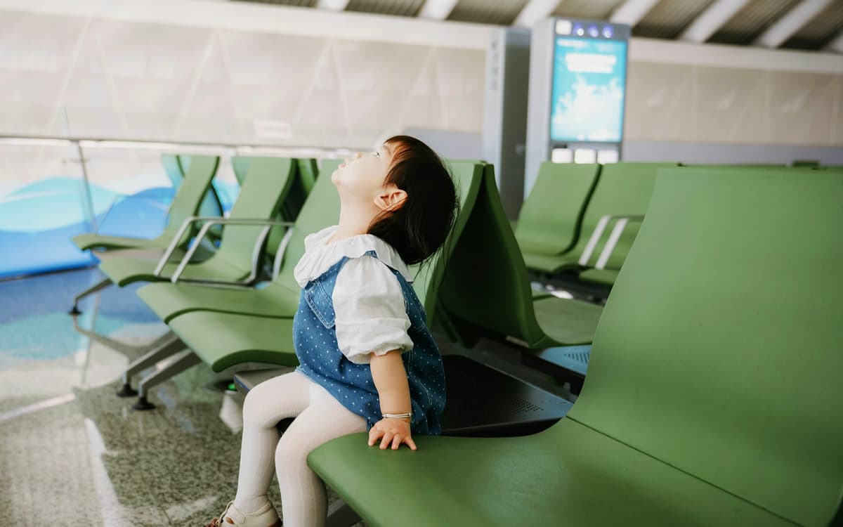 A small child waiting in an airport lounge