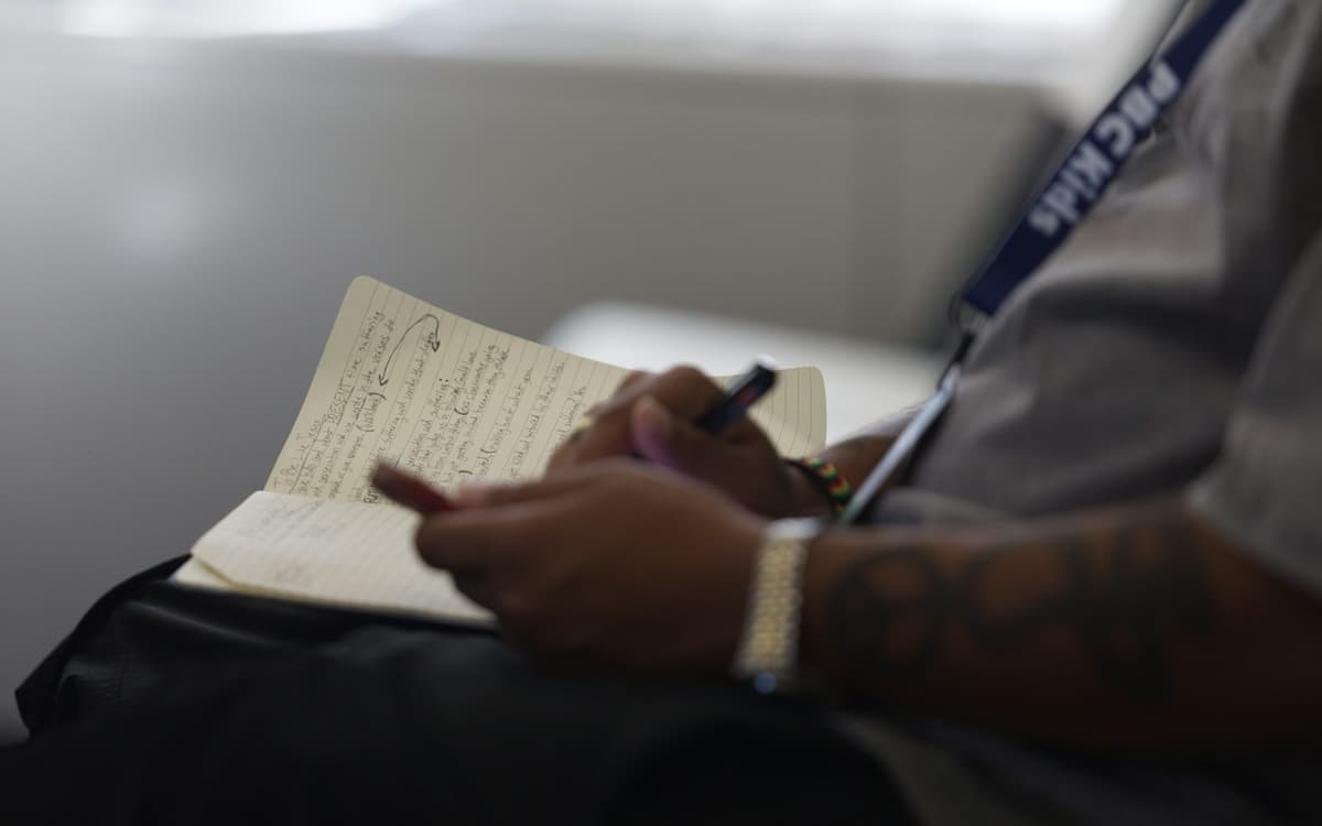 A person writing a statement in a notebook