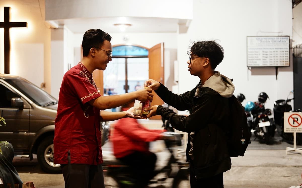 Two people handing over a vehicle’s keys in a car park