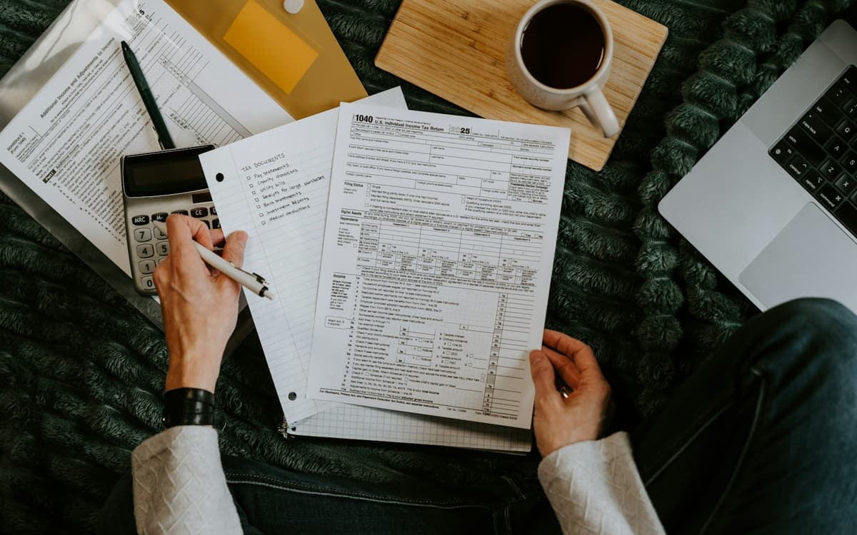 An accountant checking printed forms with a calculator