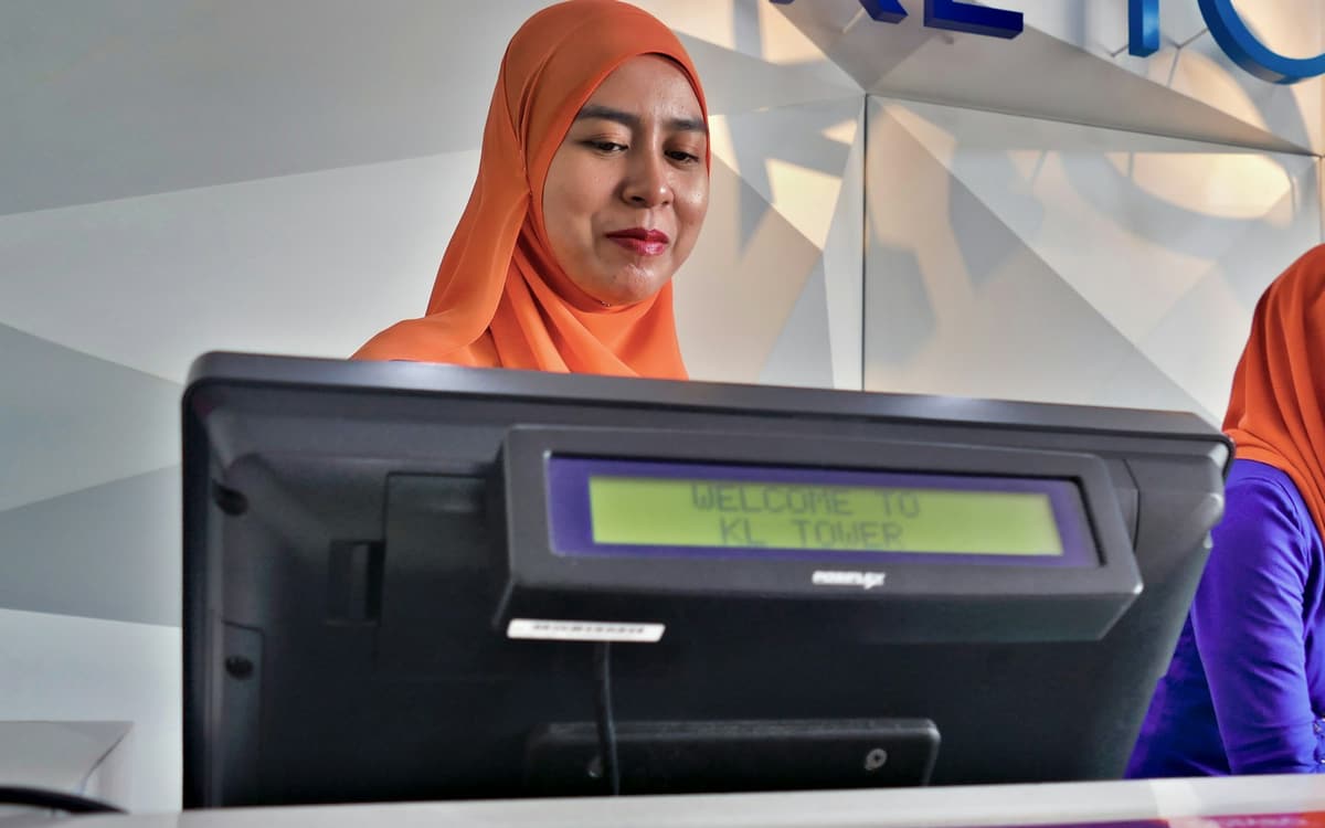 A bank teller working at a counter terminal