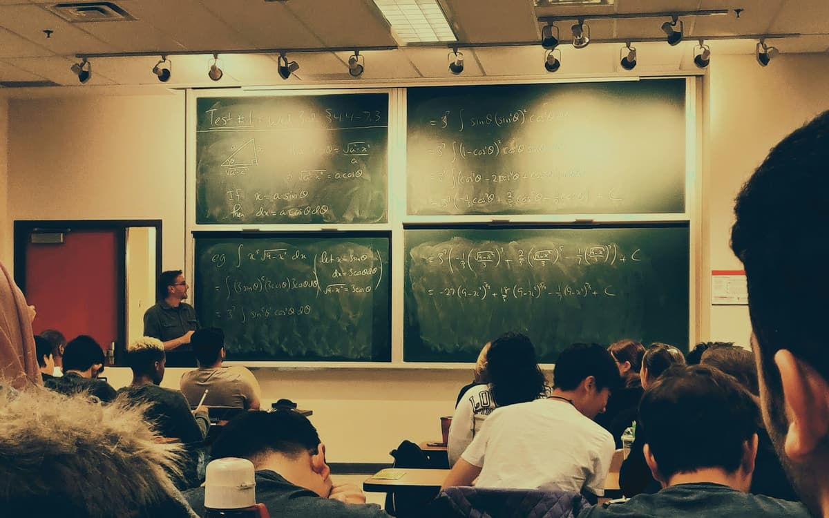 Students seated in a lecture hall facing blackboards