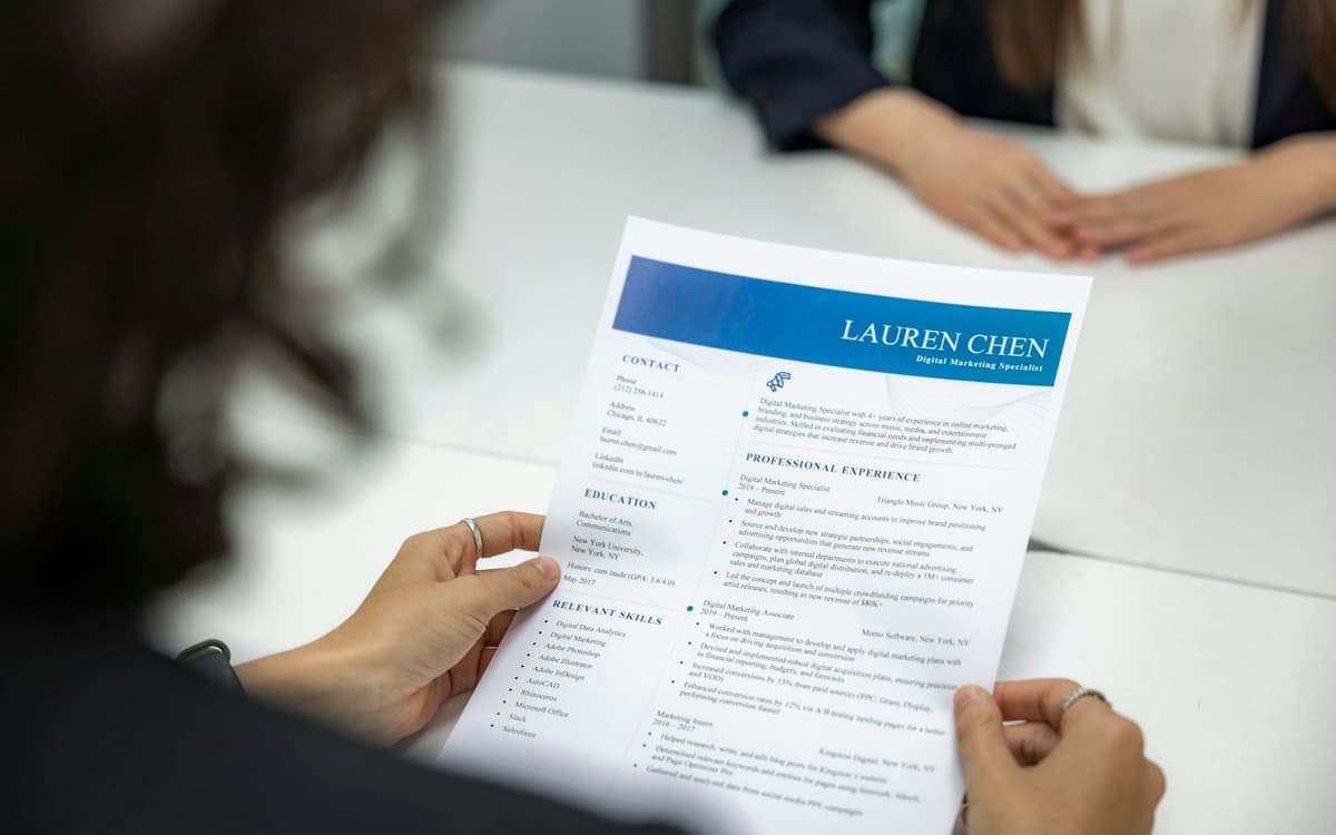 A recruiter reading a printed CV at a table