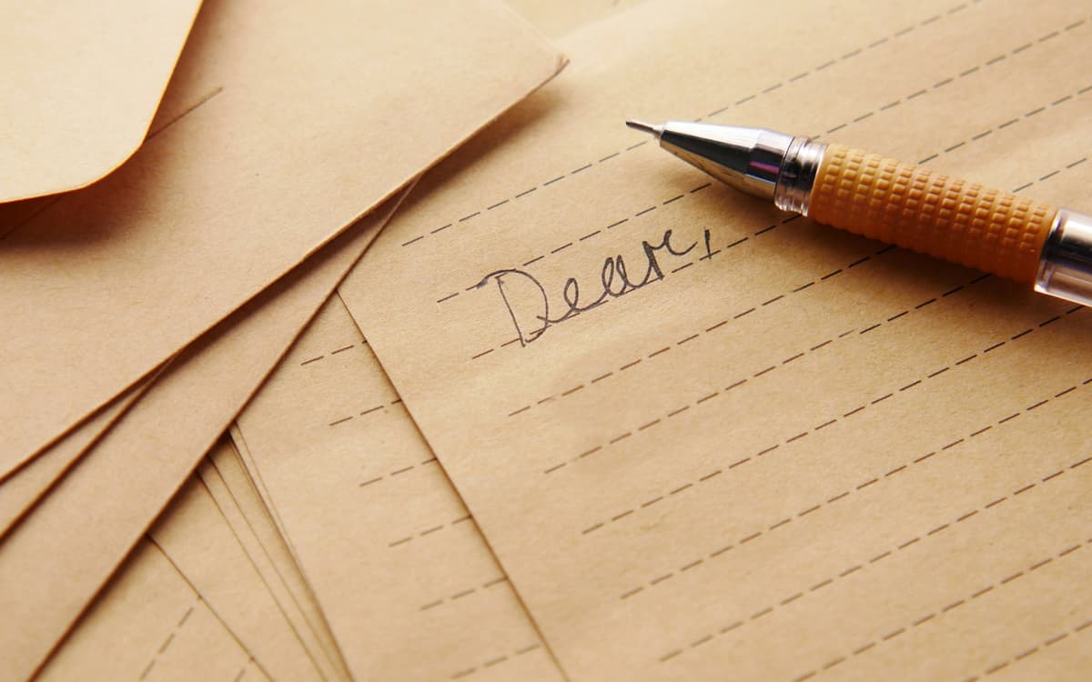 A pen resting on a letter that begins “Dear”