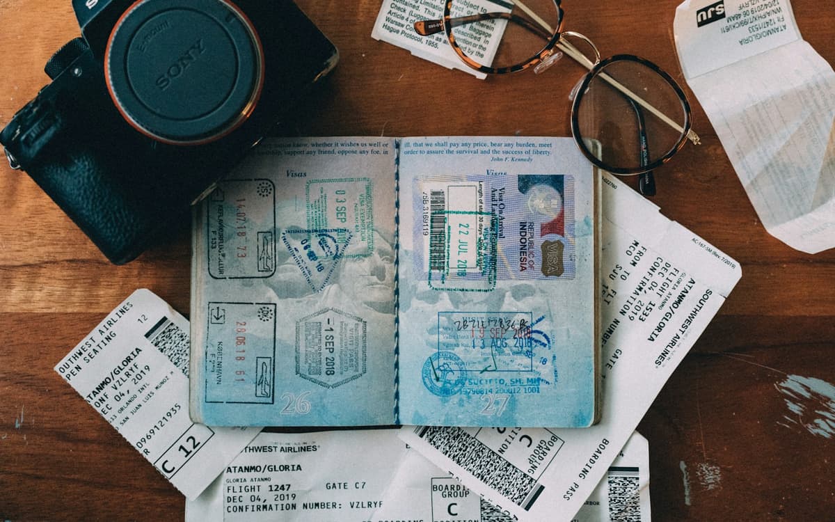 An open passport showing visa stamps, with travel documents