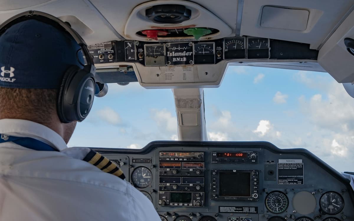 A pilot wearing a headset in the cockpit of a small aircraft