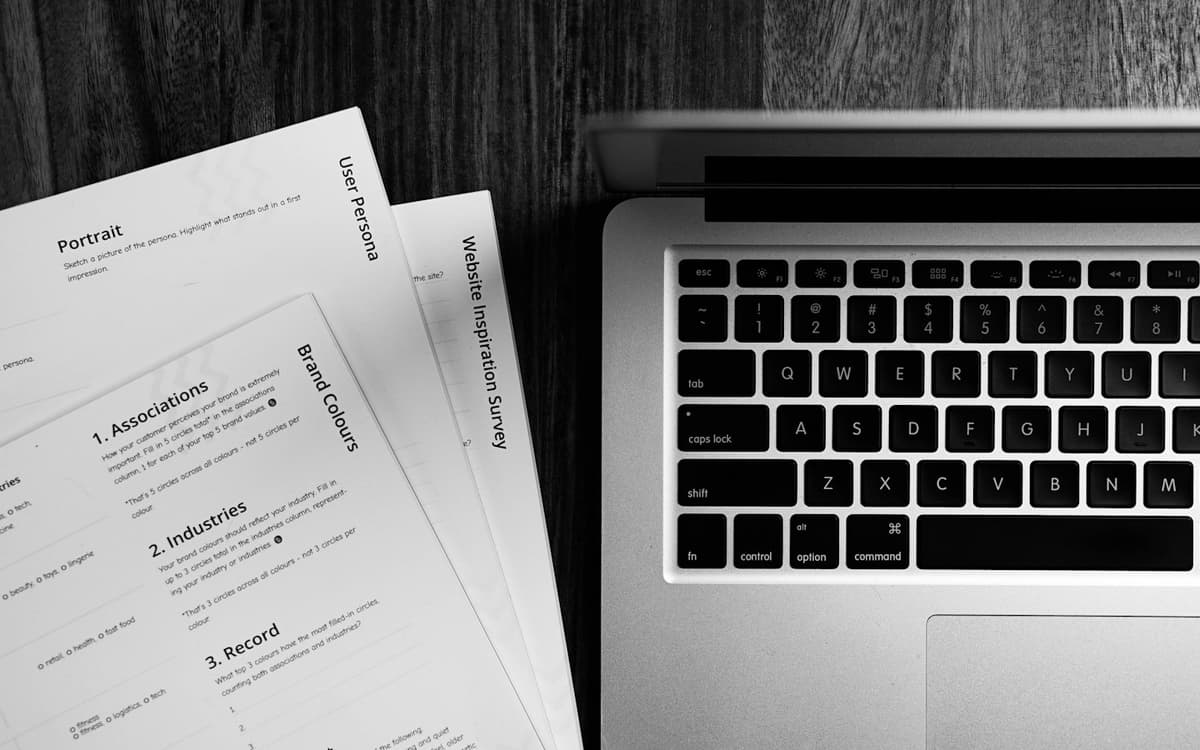 Printed CV pages beside a laptop keyboard