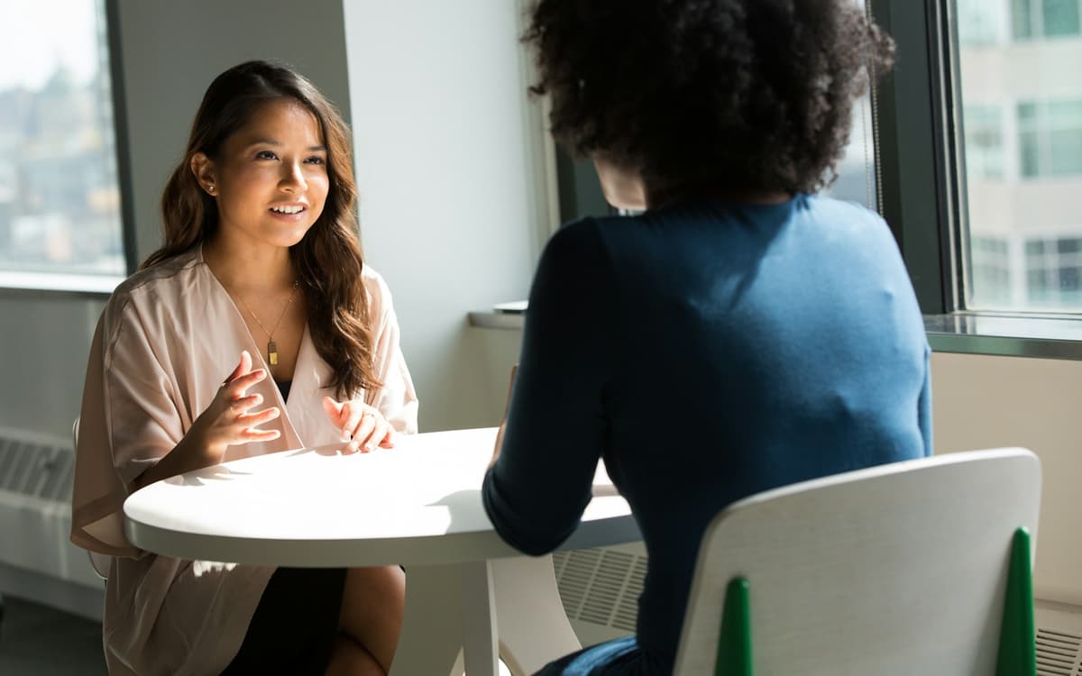 Two women talking across a table in a job interview