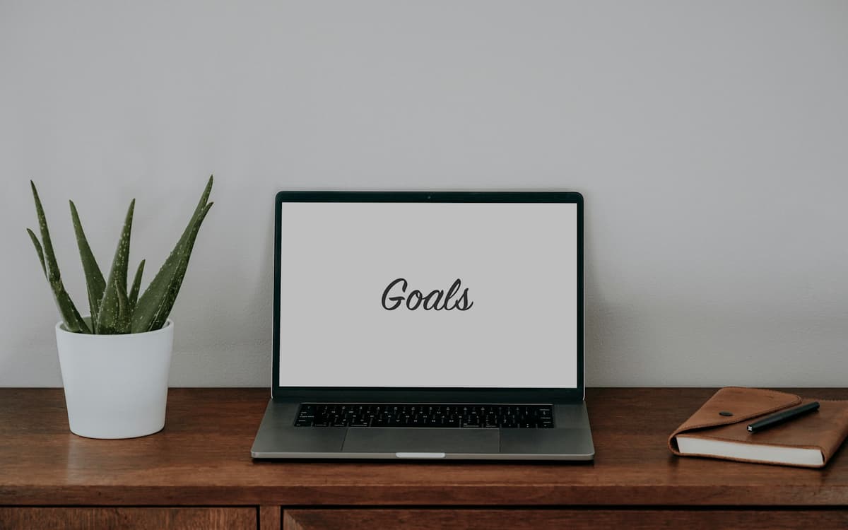 A laptop on a desk with the word “Goals” on its screen