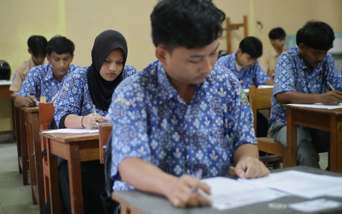 Students writing at their desks in a classroom