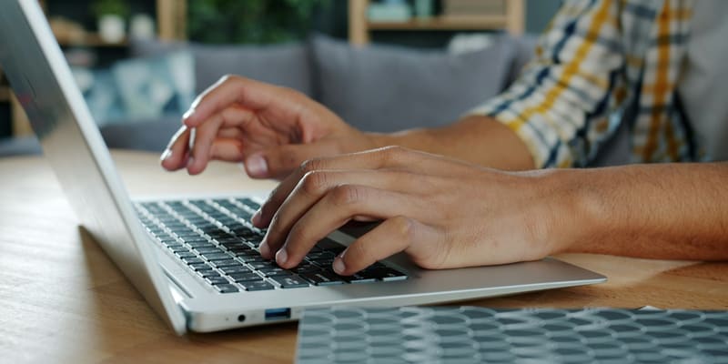 Hands typing on a laptop keyboard — Nepali Unicode, Preeti and English typing test